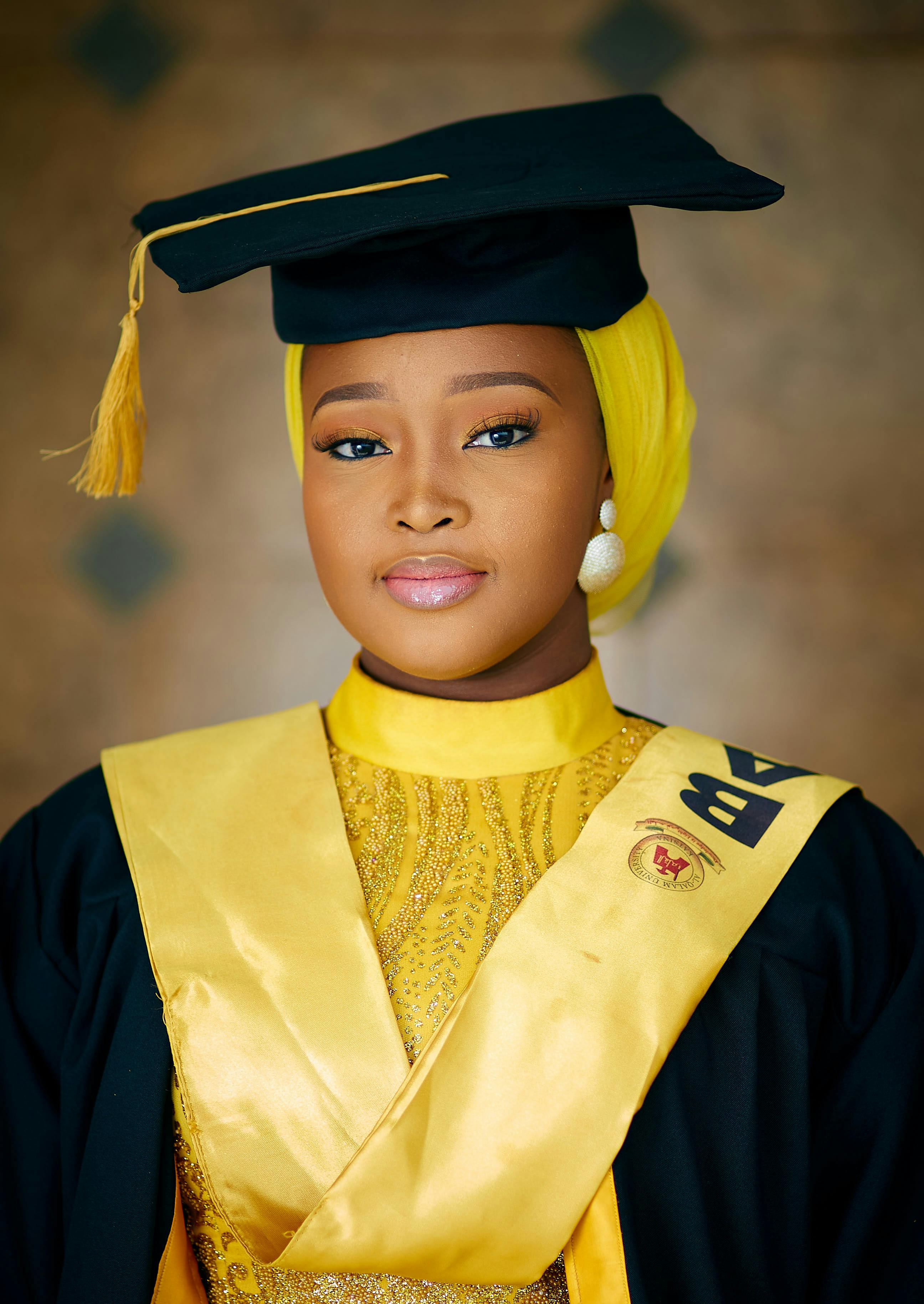 A Nigerian woman in traditional graduation attire, showcasing her academic achievement with pride.