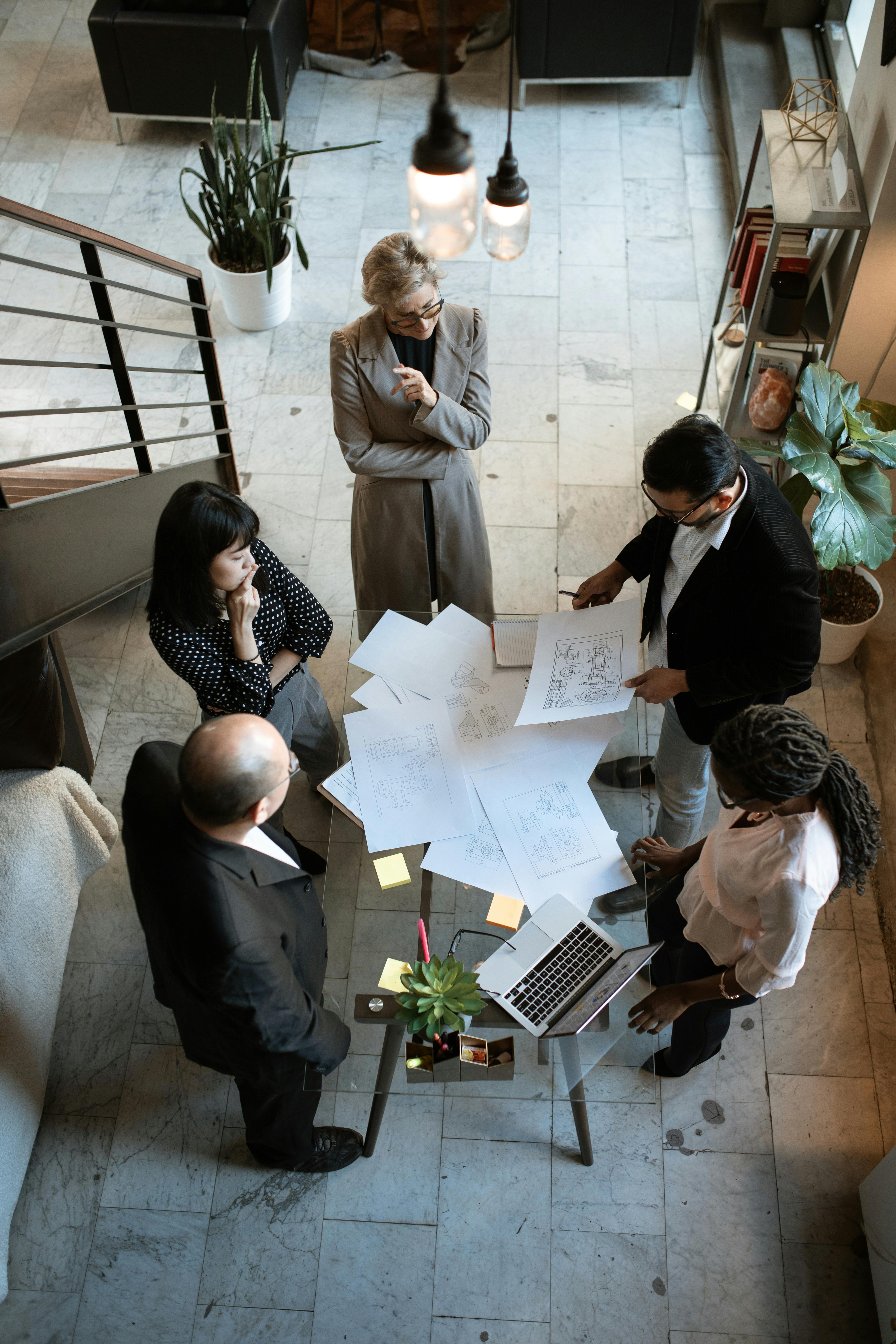 Services A team of professionals engage in a business meeting in a sleek, modern office setting.