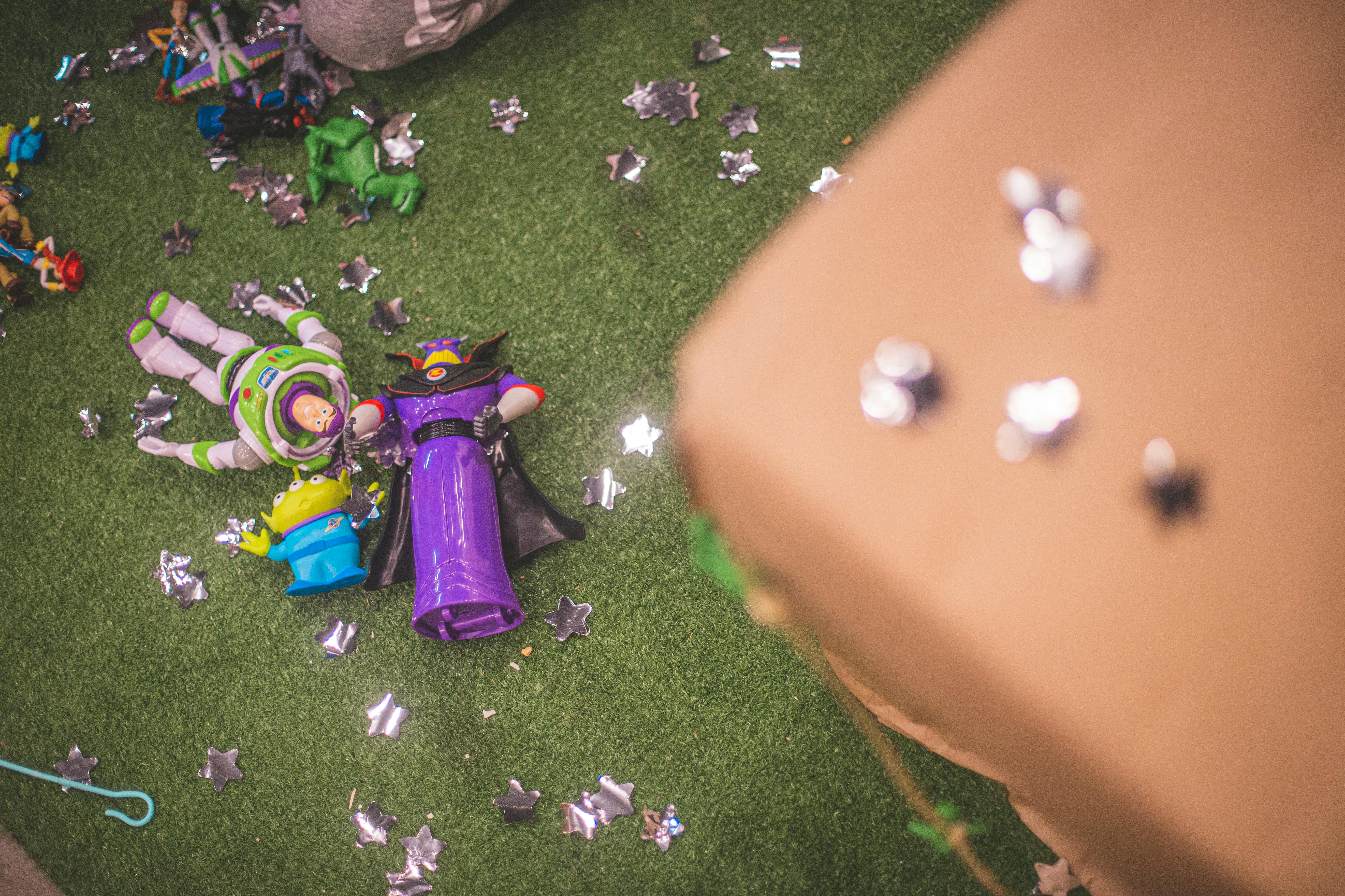 Buzz Lightyear and Zurg toy figures on artificial grass surrounded by star-shaped decorations.