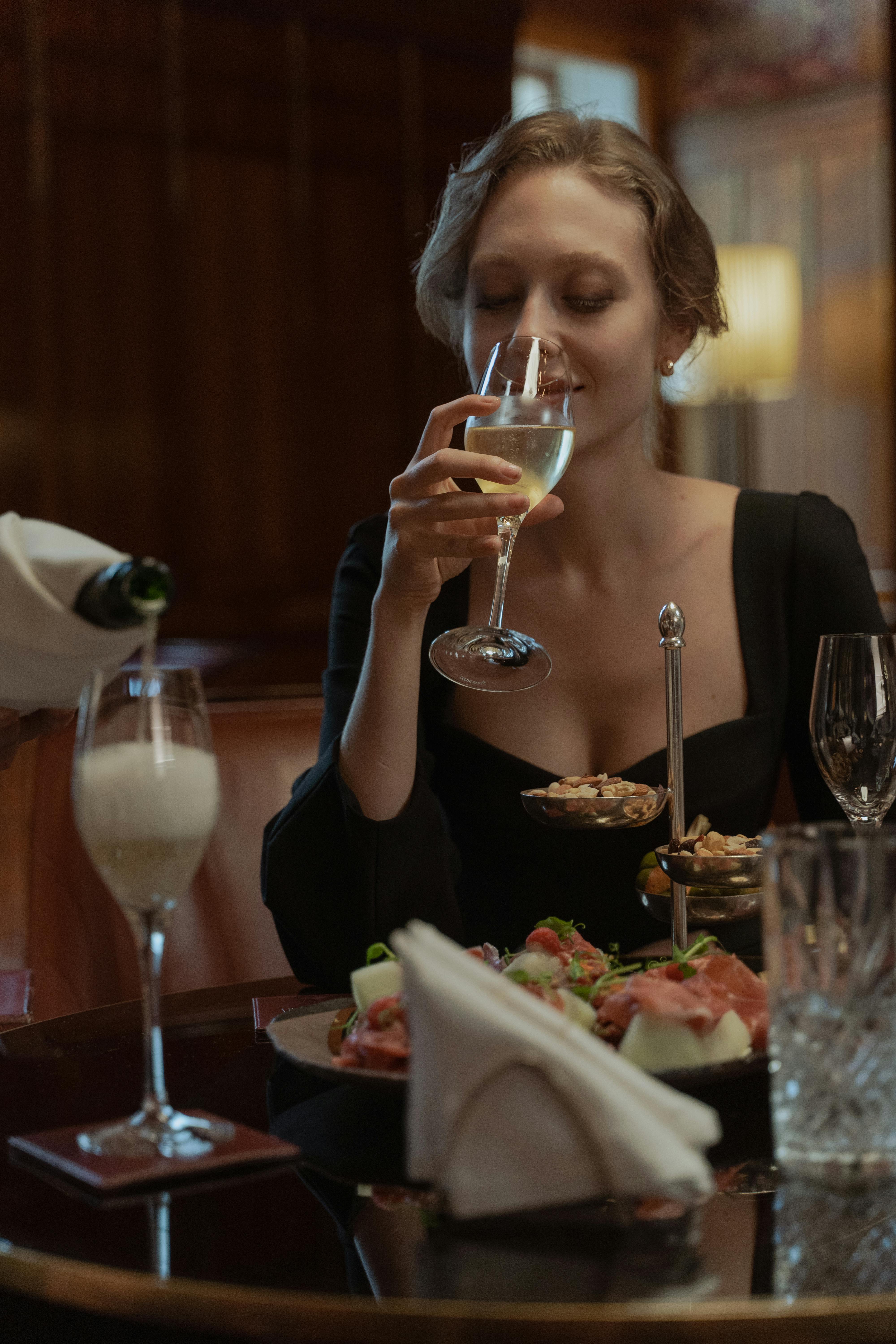 Server offering wine in intimate lounge