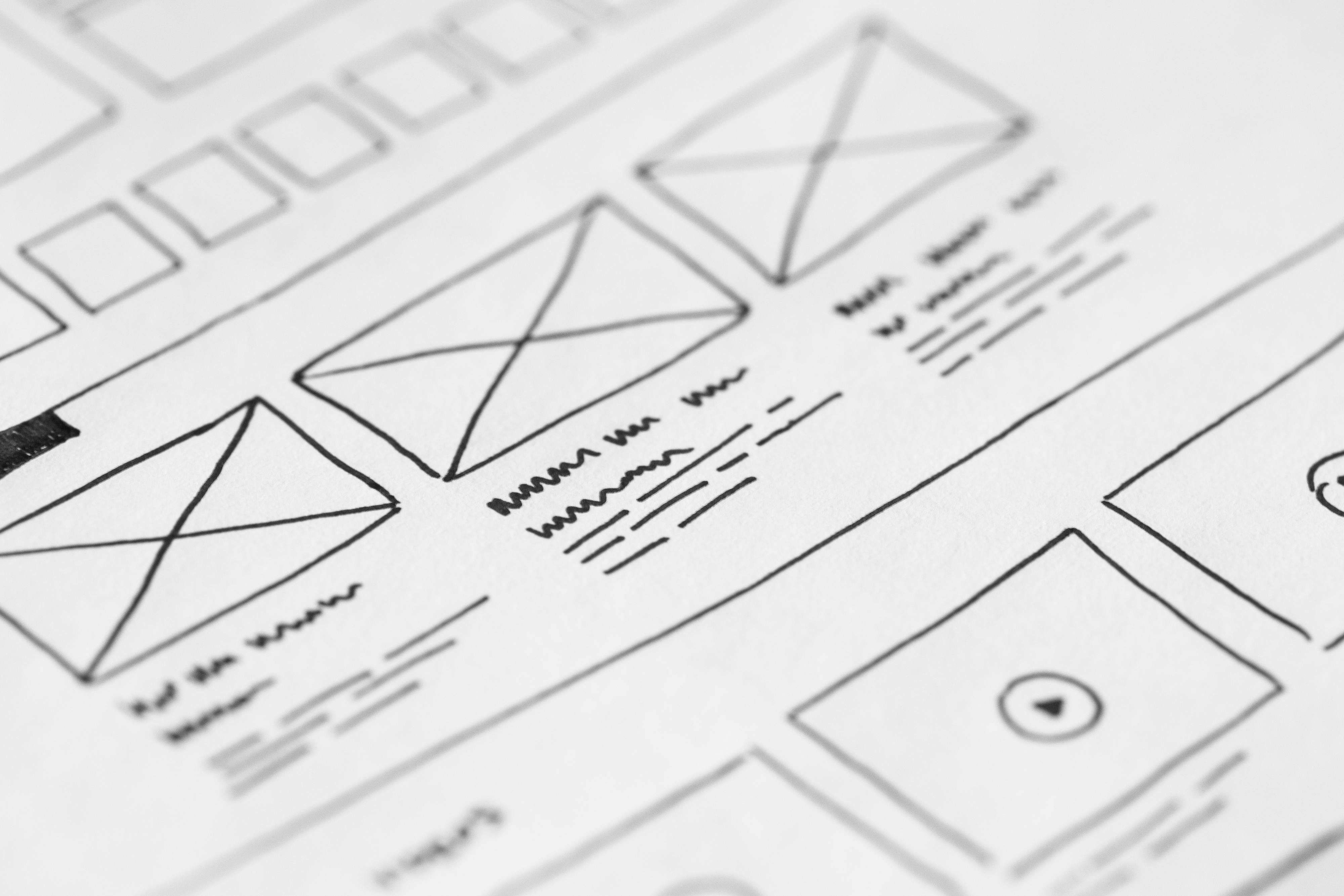 Services Detailed close-up of a hand-drawn wireframe design on paper for a UX project.