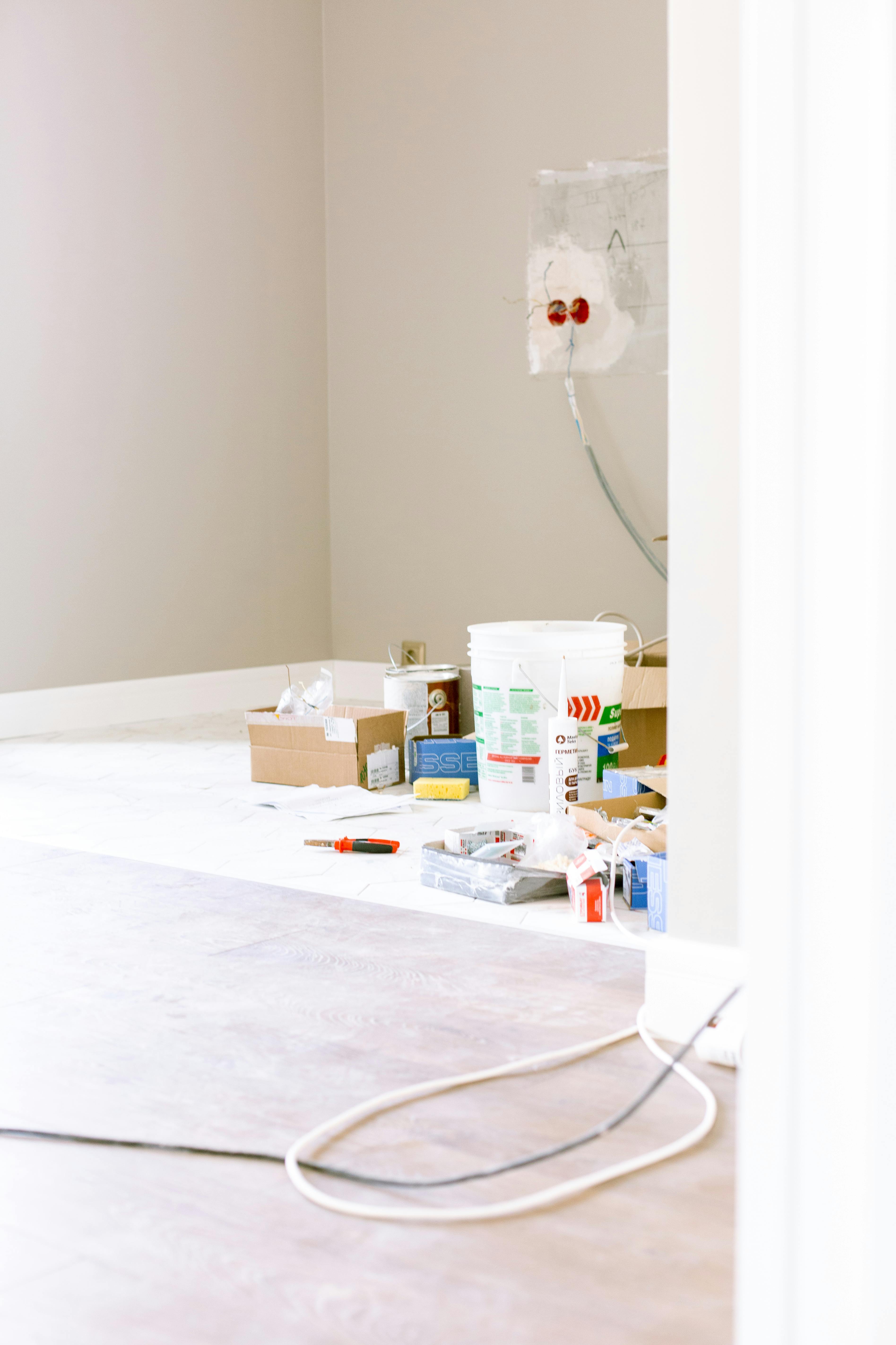 Home A room corner with renovation supplies, paint cans, and tools, ready for a home improvement project.